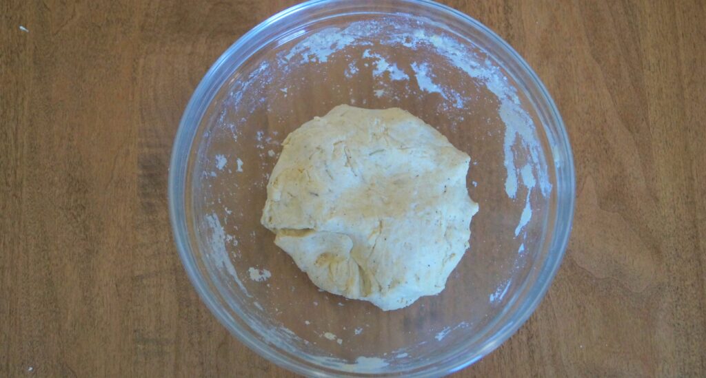 smooth dough ball for rosemary sourdough crackers in a glass bowl 