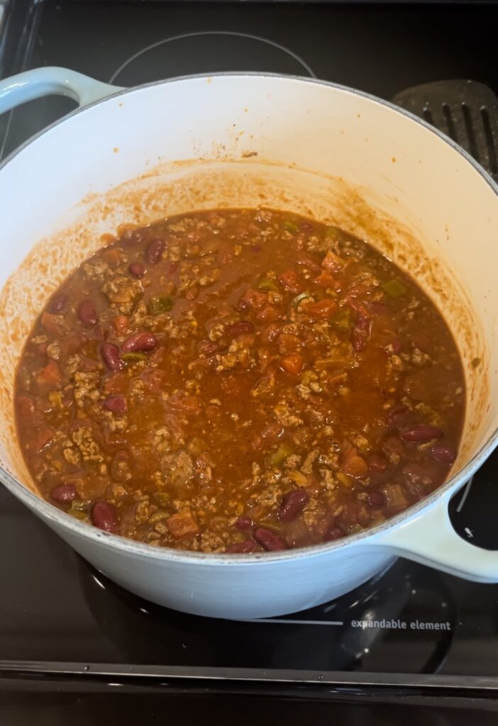 Cooked chili in a light blue pot on stove