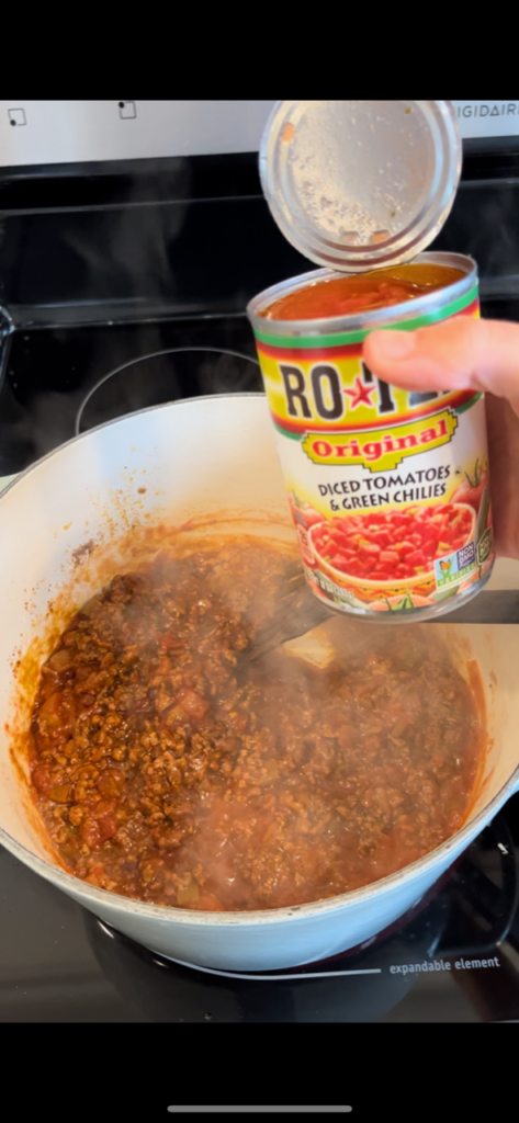 rotel held above pot of chili 